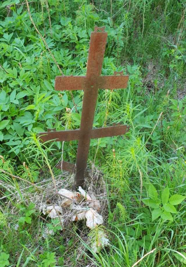 На месте бывшего захоронения в 90-е был установлен металлический крест