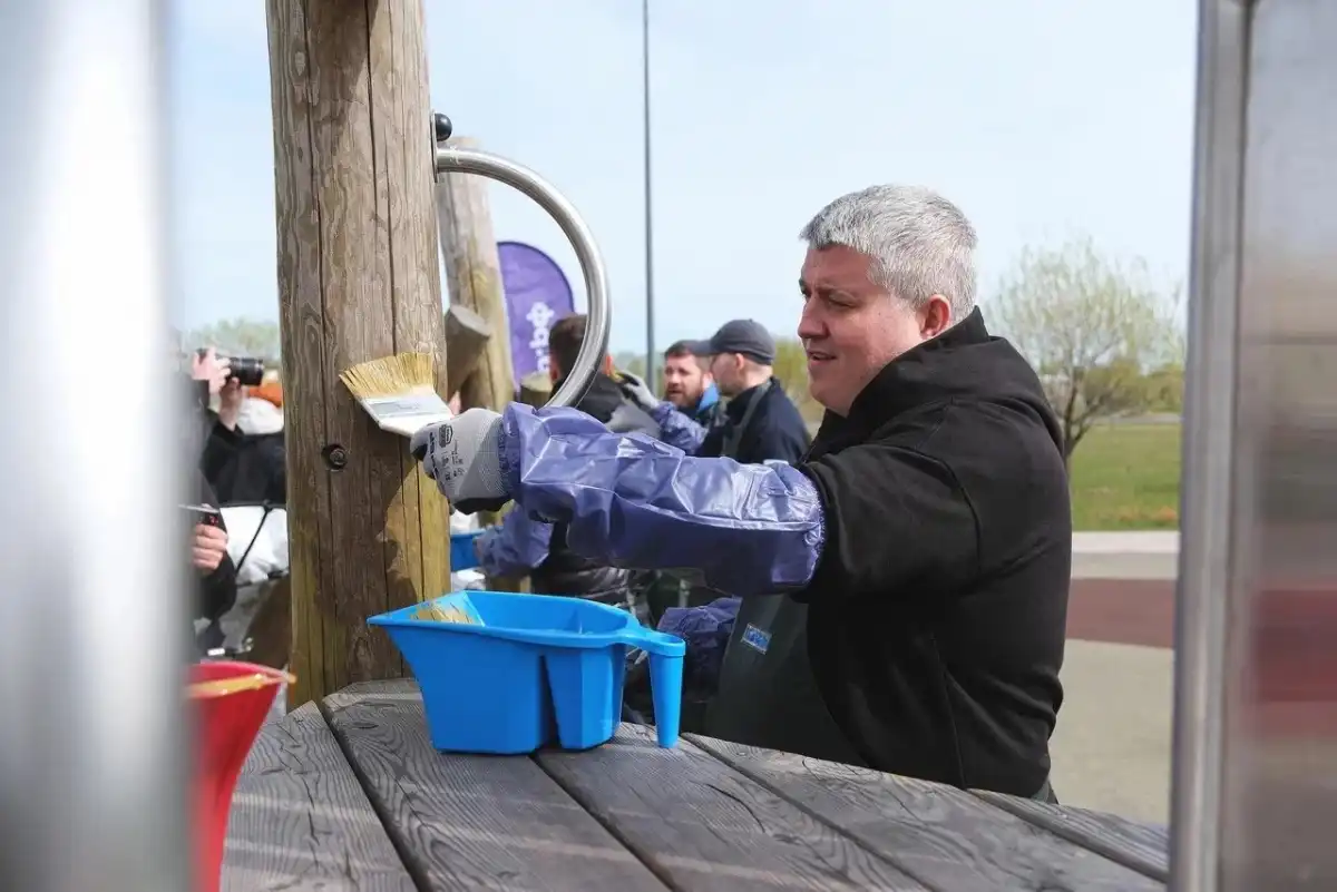 Александр Дронов и другие участники субботника на время стали малярами. Они нанесли на конструкции детской площадки специальную пропитку.