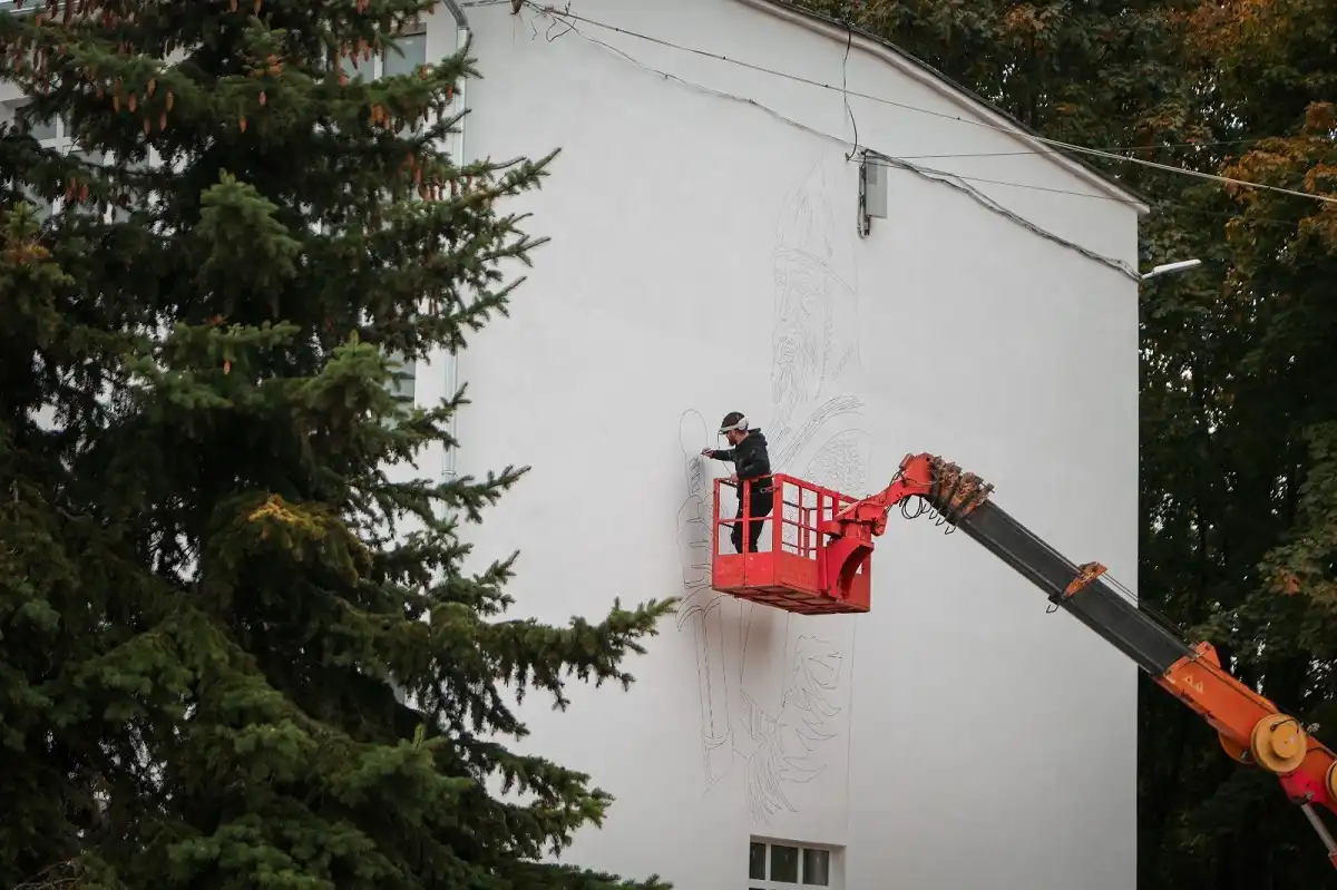 Художник Дмитрий Север создает мурал на здании школы №8.