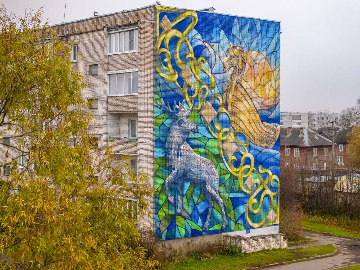 Фасад жилого дома в посёлке Парфино украсил красочный мурал с символами герба округа