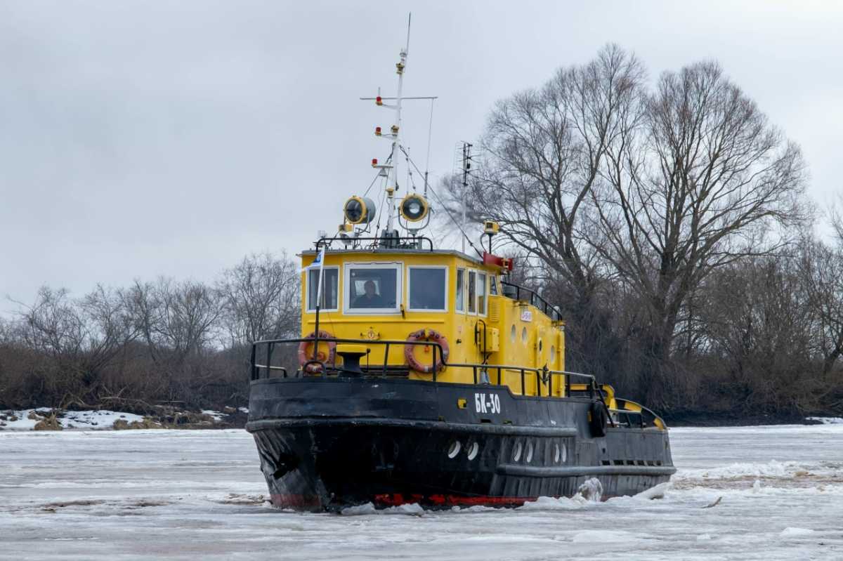Многотонный буксир с усиленным корпусом с разгона разламывает ледовое покрытие водоёма.