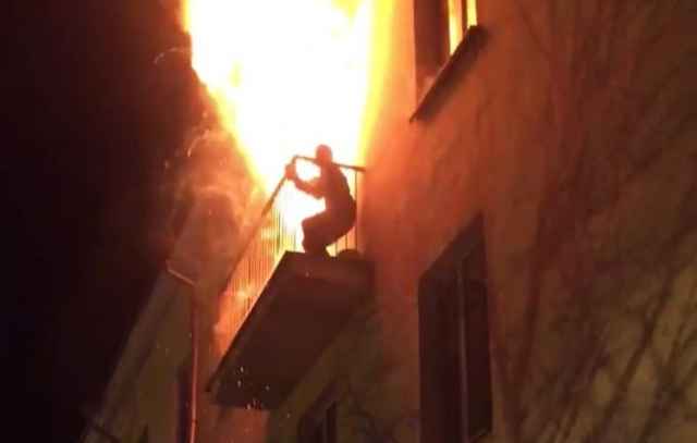 Спасаясь от пожара, на балкон горящей квартиры вышел мужчина.