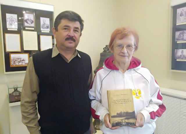Татьяна Павловна Смирнова передает книгу Андрею Иванову, директору Любытинского краеведческого музея.