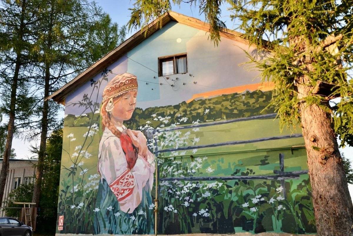Один из муралов в Любытине – девушка в национальном костюме – появился на фасаде дома на улице Советов.