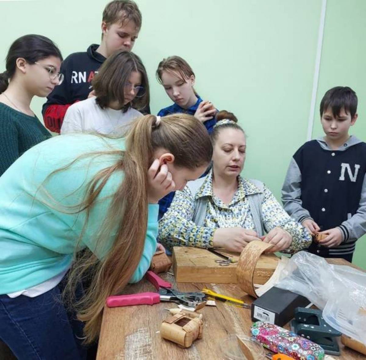 Татьяна Константинова показывает воспитанникам, как своими руками сделать подарки из бересты.