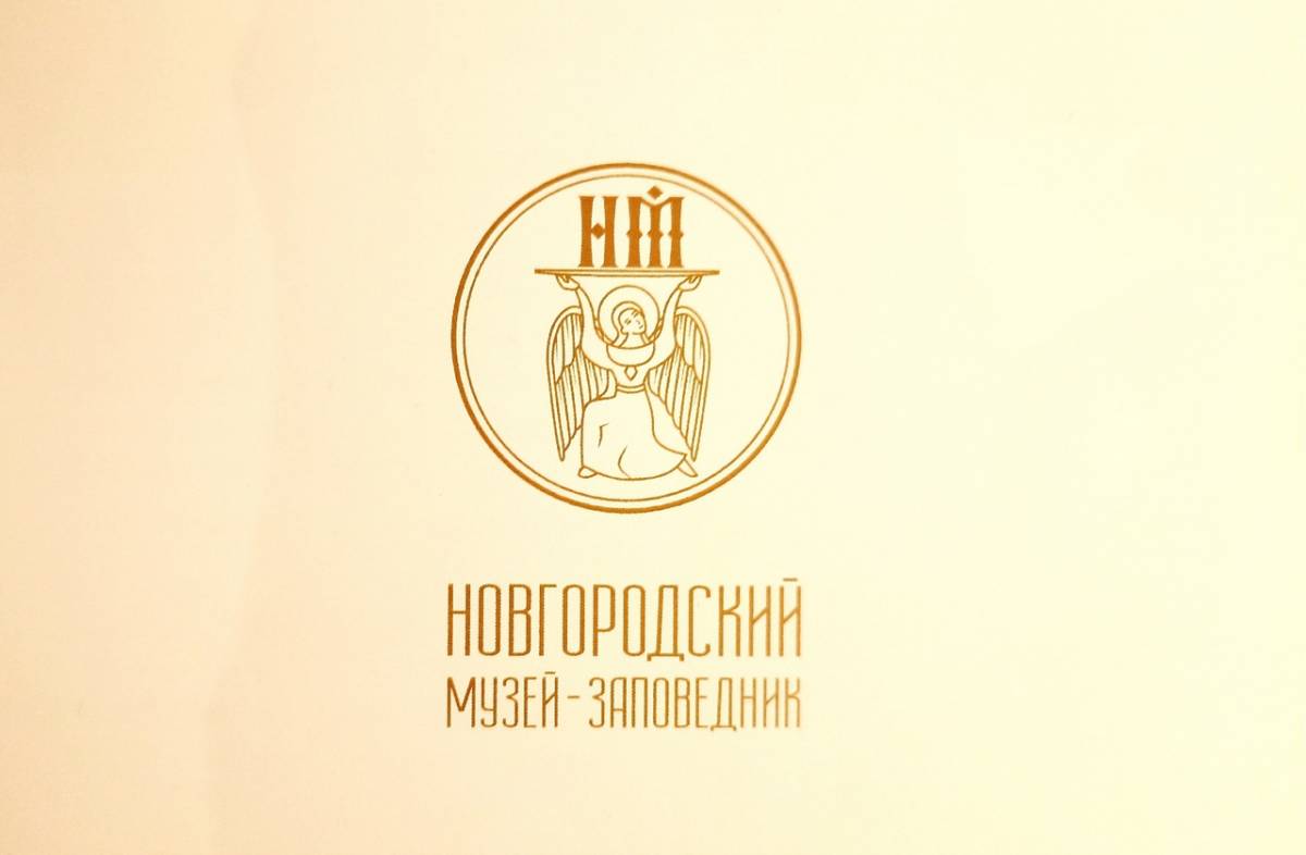 После стилизации панагиара на эмблеме музея светозарный ангел держит буквы «НМ», то есть Новгородский музей.