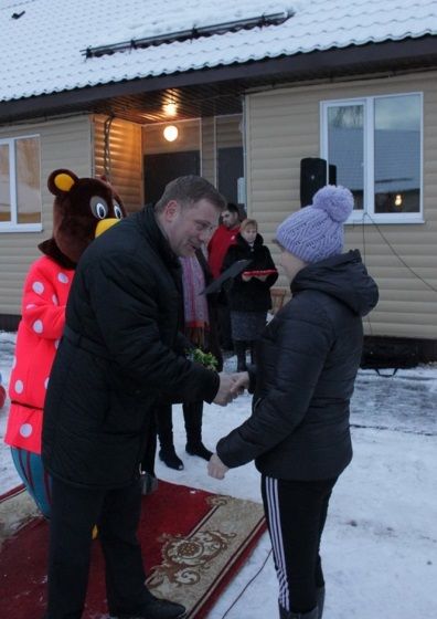 Вице-губернатор Игорь Верходанов вручает ключи от квартир пестовским новосёлам
